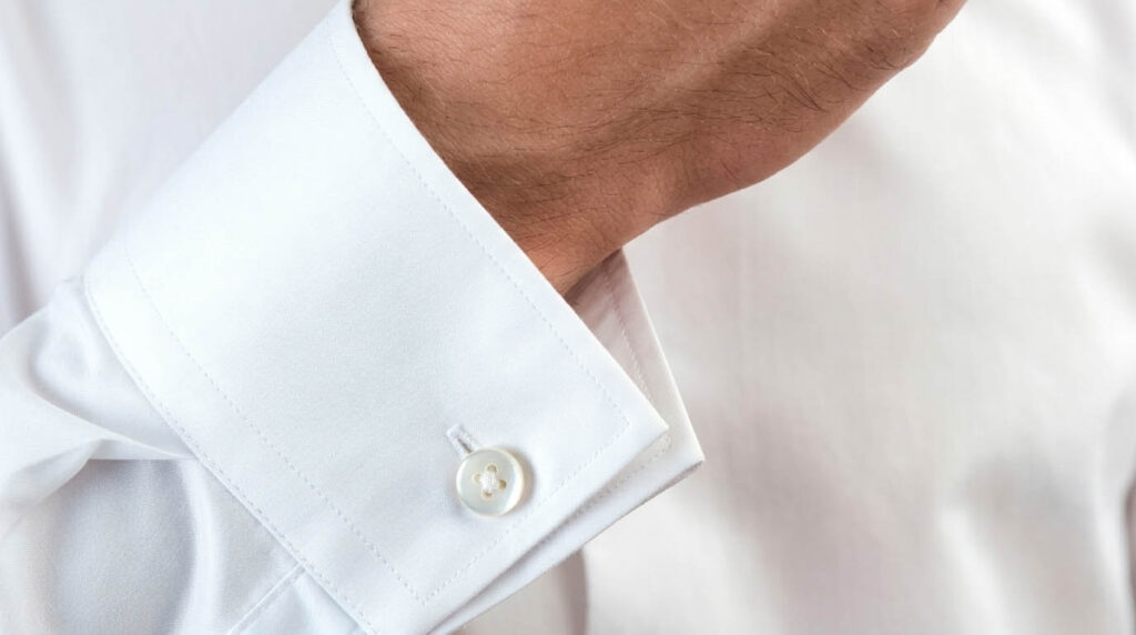Острый одинарный манжет белой рубашки, застегнутый на пуговицу.
