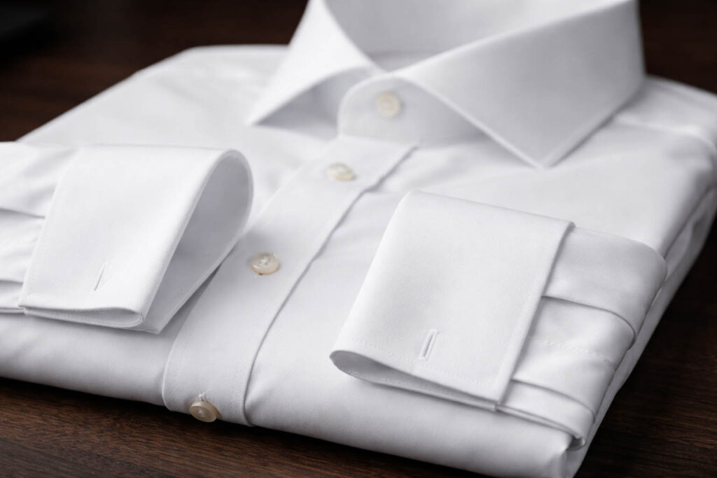Сложенная белая рубашка с французскими манжетами.